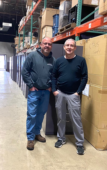 Office furniture installers pose In warehouse 
